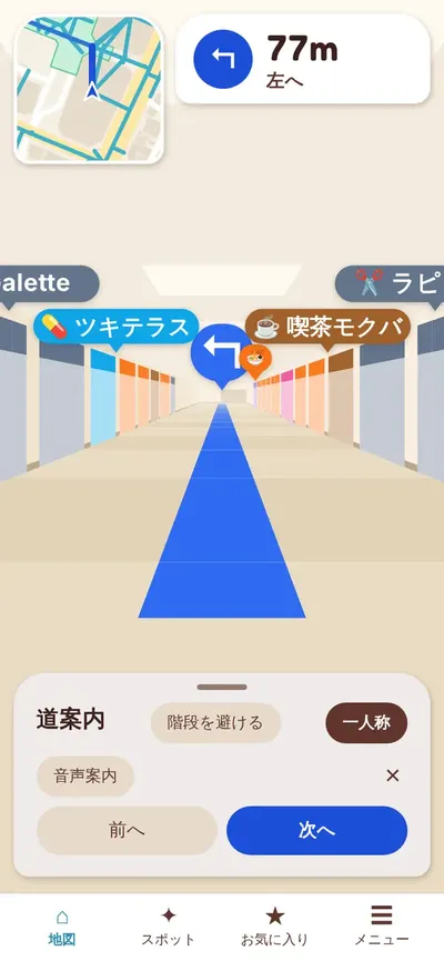 梅田地下ナビの案内中の画面。左上に進む向きが上の小さな地図と「77m 左へ」、画面いっぱいに通路の絵と左右の店の看板